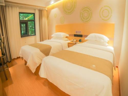 a hotel room with three beds in a room at GreenTree Inn Beijing Shunyi District Fuqian West Street Shimen Subway Station Express Hotel in Beijing