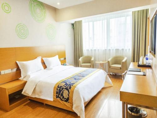 a hotel room with a large bed and a desk at GreenTree Inn Xi'an Ming City Wall Northwest Dafengqing Road Business Hotel in Xi'an