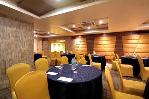 a conference room with tables and yellow chairs at Taj Tristar in Hyderabad