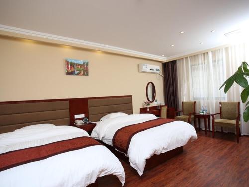 a hotel room with two beds and a chair at GreenTree Inn JiangSu KunShan Lujia Town Furong Road Express Hotel in Kunshan