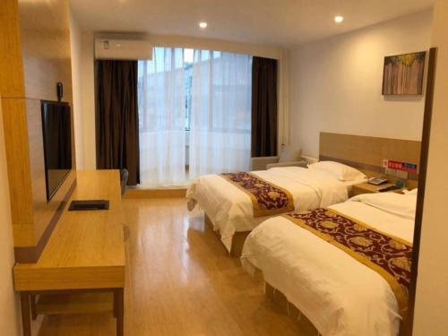 a hotel room with two beds and a flat screen tv at GreenTree Alliance Texas Railway Station Municipal Hospital Hotel in Dezhou