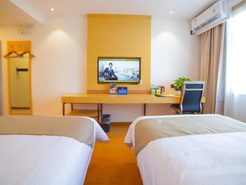 a room with two beds and a desk with a television at GreenTree Inn Beijing Shunyi District Fuqian West Street Shimen Subway Station Express Hotel in Beijing