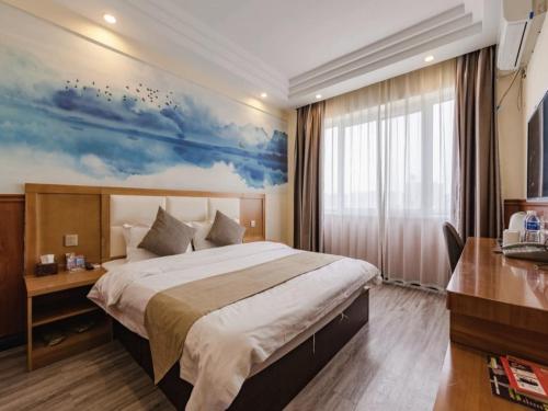 um quarto de hotel com uma cama grande e uma janela em Shell Kaifeng City Lancao County Women and Children Hospital Hotel em Kaifeng