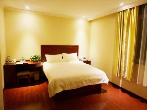 a bedroom with a white bed and a desk and a bed sidx sidx at GreenTree Inn Shandong Zaozhuang Xuecheng District Road Taishan Road Road Communist Youth League School Express Hotel in Zaozhuang