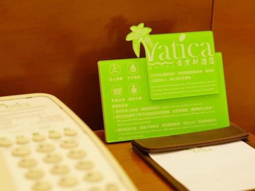 a remote control sitting next to a green card and a calculator at Vatica AnHui Fuyang Linquan South Jiefang Hotel. in Linquan