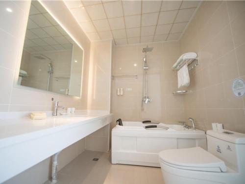 une salle de bain avec un lavabo, des toilettes et un miroir dans l'établissement GreenTree Inn Langfang City Wen'an County Beach Town Anzu Road Business Hotel, à Wen'an