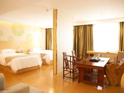 a hotel room with two beds and a table at GreenTree Inn Xianning Tongcheng Bus Station Business Hotel in Tongcheng