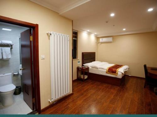 a hotel room with a bed and a bathroom at GreenTree Inn Jiangsu Huai’an Hexia Acient Town Zhou Enlai Memorial Hall Express Hotel in Huai'an
