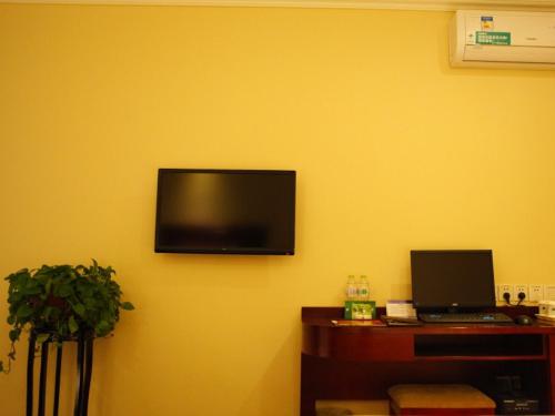 a yellow wall with a flat screen tv on the wall at GreenTree Inn Shandong Zaozhuang Xuecheng District Road Taishan Road Road Communist Youth League School Express Hotel in Zaozhuang