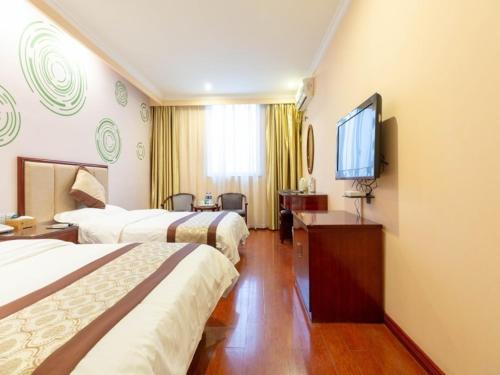 a hotel room with two beds and a flat screen tv at GreenTree Inn Jiangsu ZhenJiang Jurong New Bus Station Express Hotel in Jurong