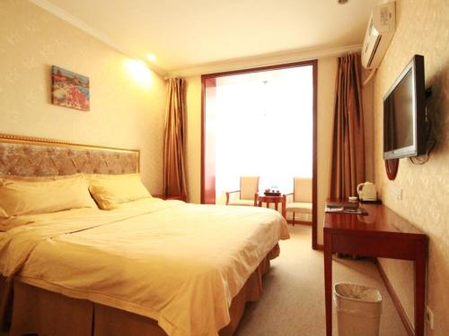 a hotel room with a bed and a television at GreenTree Inn Datong West Xiangyang Street Express Hotel in Datong