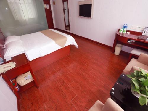 a hotel room with a bed and a desk with a desk at GreenTree Inn Yinchuan Pedestrian Street Xinhua Department Store Business Hotel in Yinchuan