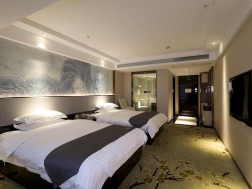 Un pat sau paturi într-o cameră la GreenTree Eastern Jingde Town Railway Station Hotel