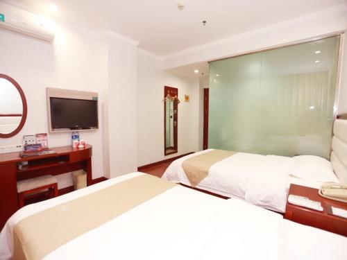 a hotel room with two beds and a flat screen tv at GreenTree Inn Yinchuan Pedestrian Street Xinhua Department Store Business Hotel in Yinchuan