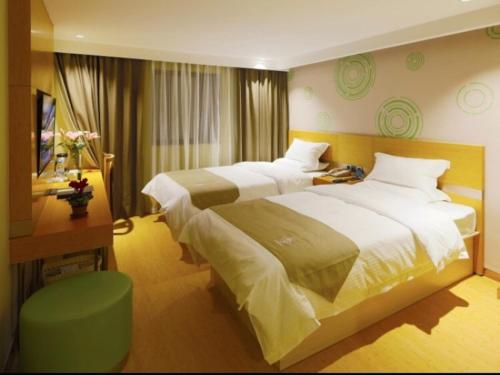 a hotel room with two beds and a desk at GreenTree Inn Shangrao Guangfeng District Huaxi Auto Trade City Business Hotel in Shangrao