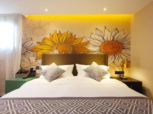 a bedroom with a large bed with flowers on the wall at GME Hefei Sanxiaokou Chenghuang Temple Xinghua Park Hotel in Hefei