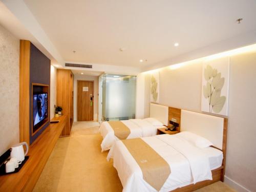 a hotel room with two beds and a flat screen tv at GreenTree Inn Liao Cheng Shen Country Bus Station Business Hotel in Liaocheng