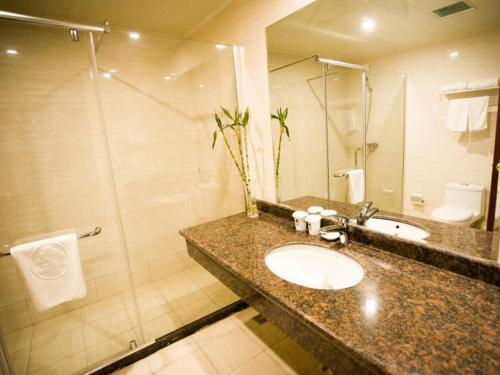 a bathroom with a sink and a shower at GreenTree Inn JIangSu XuZhou PeiXian Bus Station TangMu Road Business Hotel in Pei
