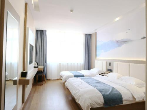 um quarto de hotel com duas camas e uma grande janela em VX hotel Nanjing South Railway Station Daming Road Metro Station em Nanquim