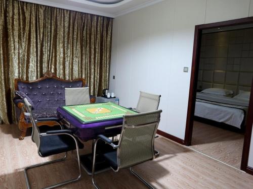 a room with a table and chairs and a bed at GreenTree Alliance Jinhua Dongyang East Bus Station Dongyong Road Hotel in Dongyang