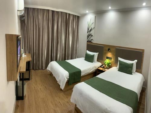 a hotel room with two beds and a window at GreenTree Inn Shandong Jinan Tianqiao District Railway station square Express Hotel in Jinan