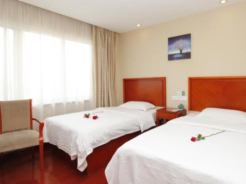 a hotel room with two beds and a chair at GreenTree Inn Rizhao West Station Suning Plaza in Rizhao
