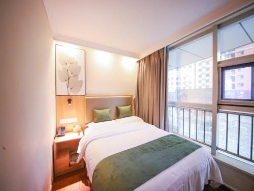 a bedroom with a bed and a large window at GreenTree Inn Anhui Hefei West Wangjiang Road Qianshan Road Express Hotel in Hefei