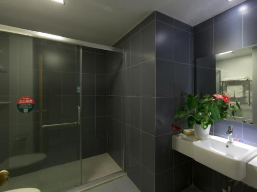 W łazience znajduje się prysznic, umywalka i lustro. w obiekcie GreenTree Inn JiangSu XuZhou JiaWang Government Express Hotel w mieście Xuzhou