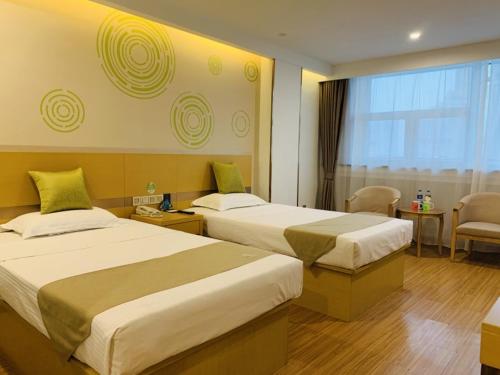a hotel room with two beds and a window at GreenTree Inn Tianjin Hedong District Tianjin Station Front Square Express Hotel in Tianjin