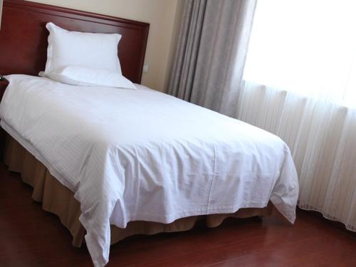 Postel nebo postele na pokoji v ubytování GreenTree Inn Shandong Weihai Wendeng Darunfa Business Hotel