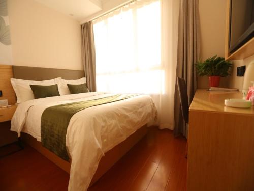 a bedroom with a large bed and a window at GreenTree Inn Hebei Langfang Development Zone Convention and Exhibition Centre Business Hotel in Langfang