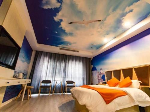 een slaapkamer met een groot bed met een schilderij van een hemel bij Shell Suzhou City Lingbi County Yingbin Avenue Yingbin Town Hotel in Suzhou
