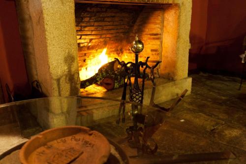 a fireplace with a glass table in front of it at Casa Rural con encanto "Los Postigos" in Baños de Montemayor