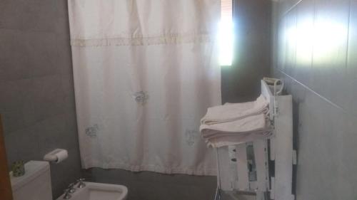 a bathroom with a shower curtain and a toilet at Cabaña de montaña in Cosquín