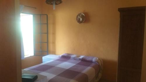 a bedroom with a bed with a plaid blanket at Cabaña de montaña in Cosquín
