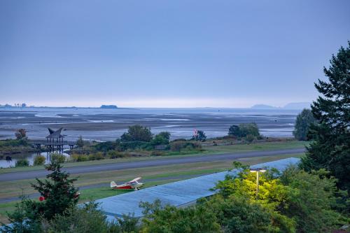 an airplane is parked on the grass next to a runway at Bayview Hotel in Courtenay