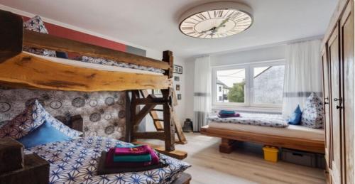 a bedroom with two bunk beds and a clock on the wall at Ferienhaus Vulkaneifel Haus Pesch in Brockscheid