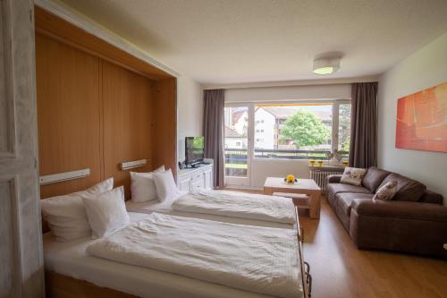 a hotel room with two beds and a couch at Alpenglück Whg. 20 in Garmisch-Partenkirchen