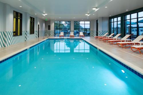 a large swimming pool with chairs and a swimming pool at Holiday Inn & Suites - Idaho Falls by IHG in Idaho Falls