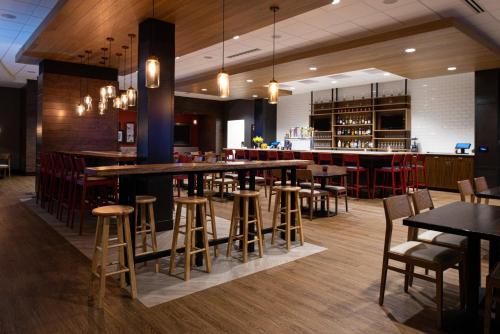 a restaurant with tables and chairs and a bar at Holiday Inn & Suites - Idaho Falls by IHG in Idaho Falls