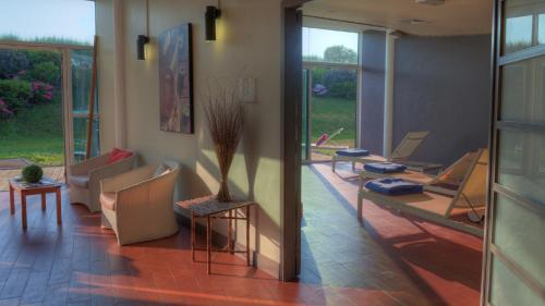 a living room with chairs and a table and windows at Les Terrasses d'Atlanthal in Anglet