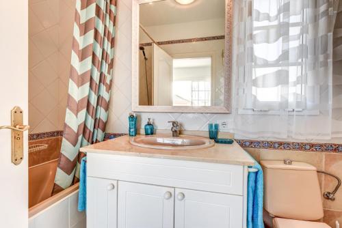 a bathroom with a sink and a toilet and a mirror at Villa Aloe con piscina climatizada, Playa Fañabe, Costa Adeje in Adeje