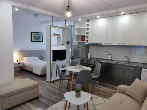 a kitchen and a living room with a bed and a table at E&A Apartments Guesthouse in Durrës