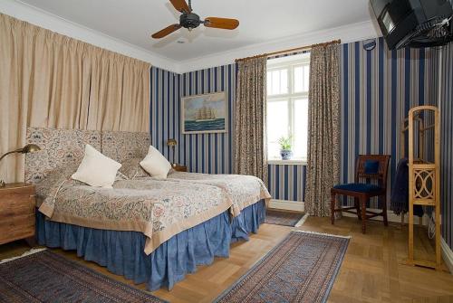 a bedroom with a bed and a ceiling fan at Hotel Kullaberg - Sweden Hotels in Mölle