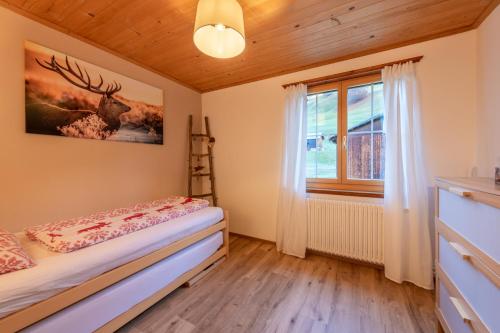 a bedroom with a bed and a window at Florin Ferien in Klosters
