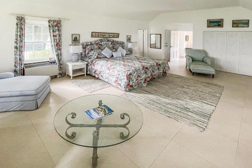 a bedroom with a bed and a glass table at Coral Sea private beachfront panorama with infinity pool in Tuckerʼs Town