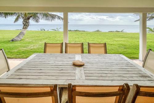 a wooden table with a hat sitting on top of it at Coral Sea private beachfront panorama with infinity pool in Tuckerʼs Town