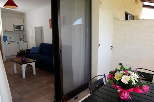 a room with a table with a vase of flowers on it at Thalacap Camargue in Saintes-Maries-de-la-Mer