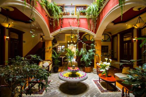 un gran vestíbulo con una gran fuente y plantas en Hotel Spa Mansion Santa Isabella, en Riobamba