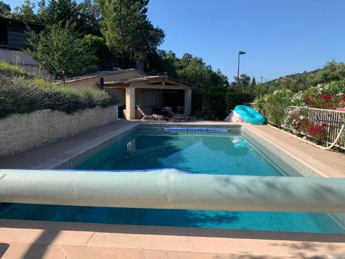 a swimming pool with a frisbee in a yard at Chalet de charme tout confort in Les Adrets de l'Esterel